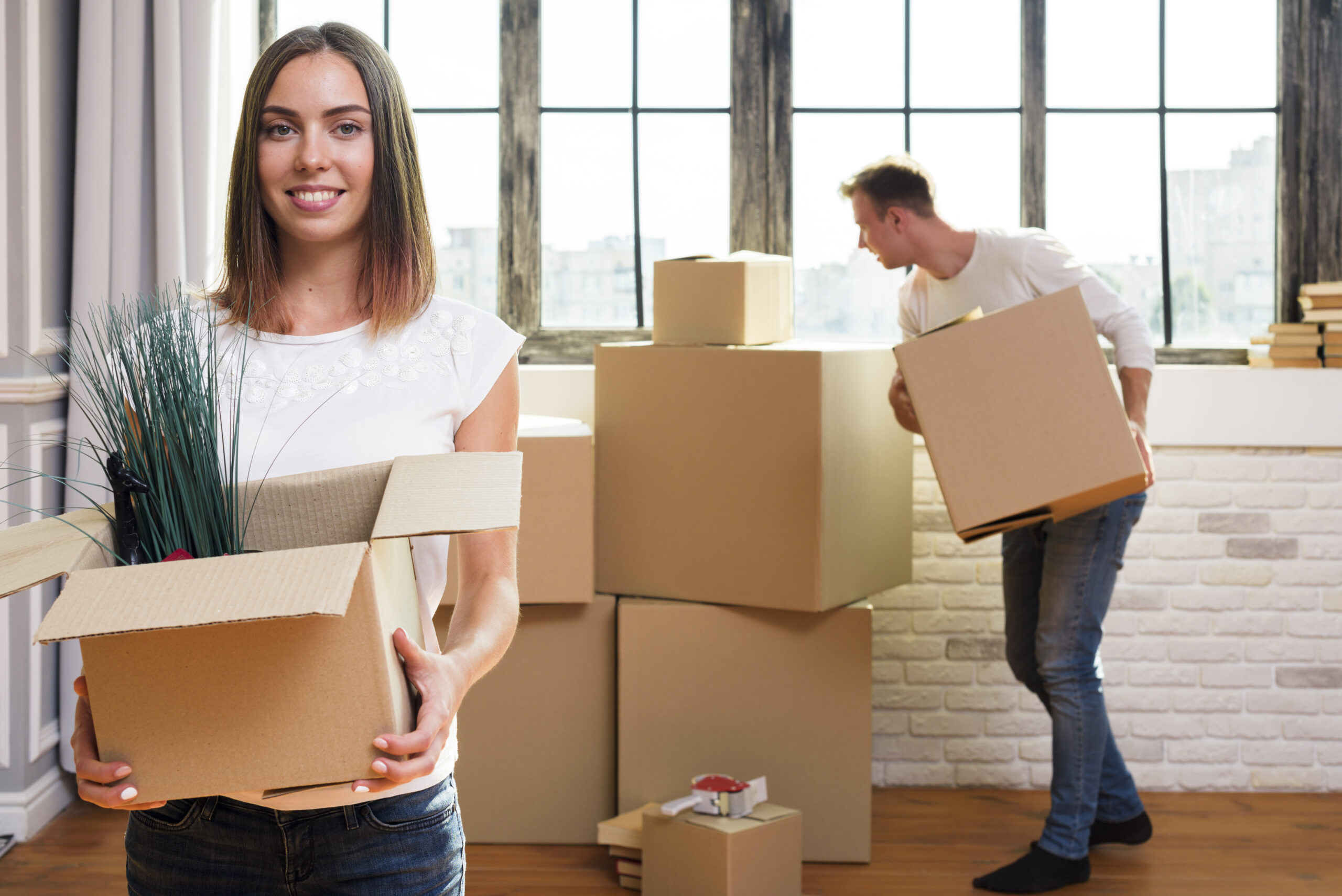 woman holding cardboard box with plants